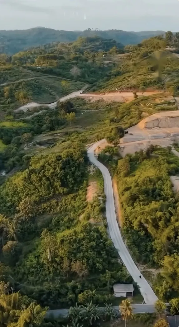 Vista aérea del camino de acceso que sube por la colina hasta el terreno de Thalassa Hills
